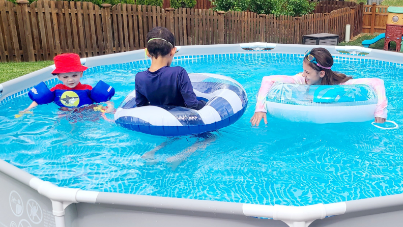 Three children swim in the Intex above ground pool.