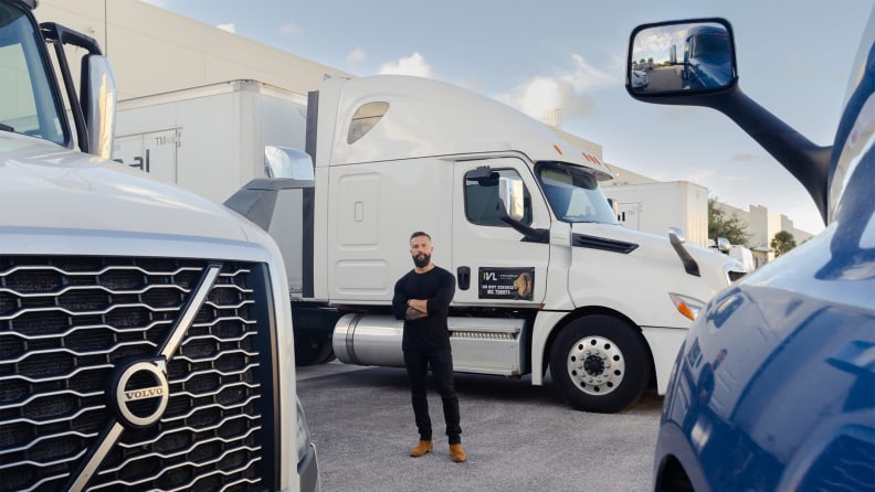 A man stands in front of a white moving truck