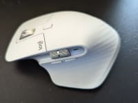 A white Logitech computer mouse sits on a surface.