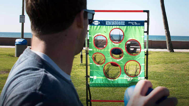 A person throws a sandbag into a goal.