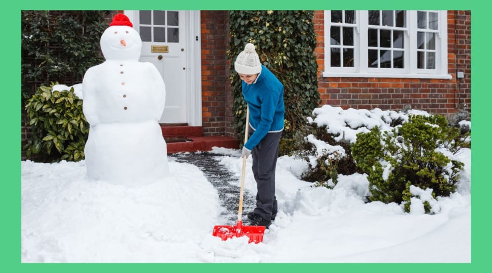 A person shoveling snow in the front yard