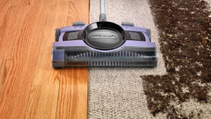 Shark V2950无绳清扫器的特写照片，它是淡紫色的，正在清洁脏地毯。