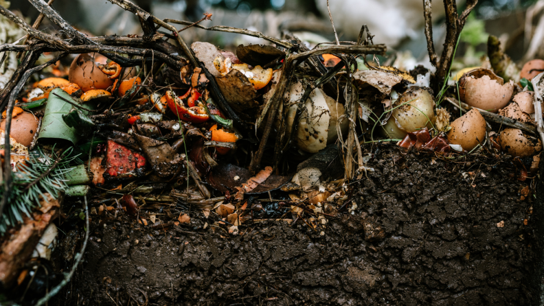 A close up view of layered dirt and vegetable scraps