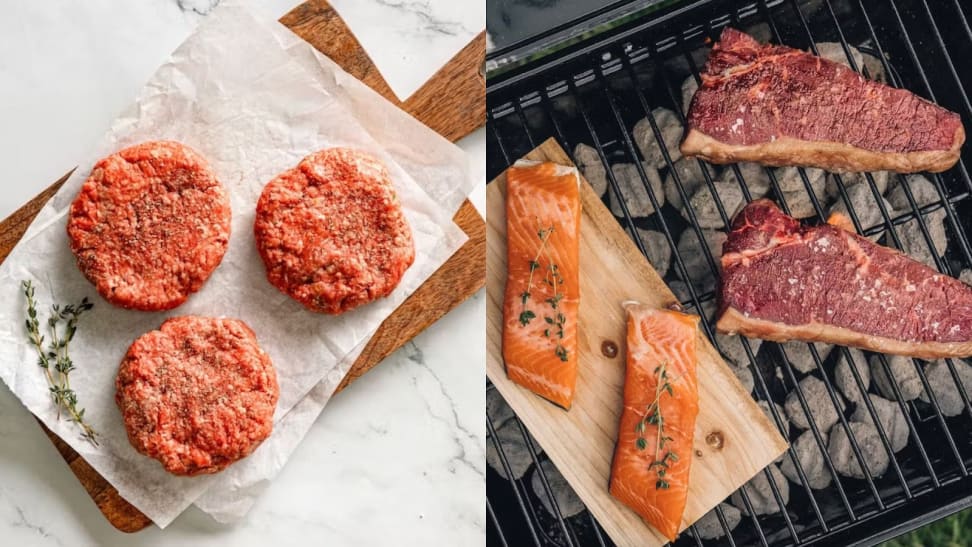 On left, three raw hamburger patties on parchment paper on top of wooden cutting board. On right, raw salmon filets and NY strip steaks on wire rack above coals inside of grill.