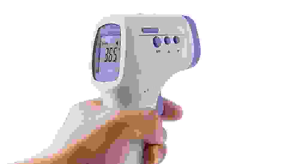 Close-up photo of a model holding a digital thermometer.