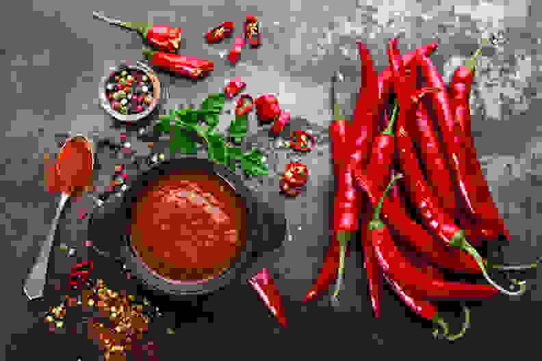 peppers and hot spices sit on a gray surface