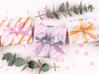 An assortment of colorfully packaged wedding presents surrounded by eucalyptus sprigs.