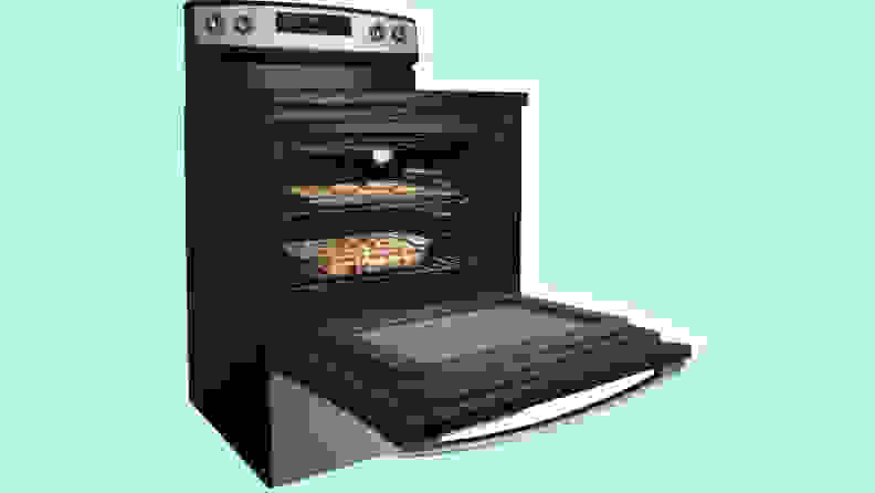 An open stainless steel oven against a green background.