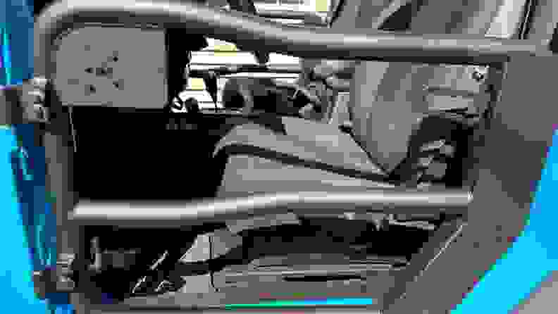 Close-up view of a black Rugged Ridge Fortis Tube Door installed in a light blue Jeep.