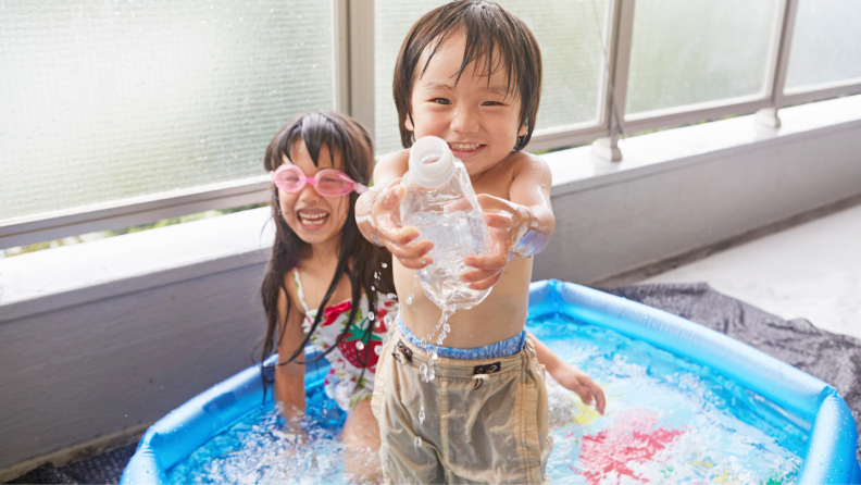 Brother and sister playing in a kiddie pool