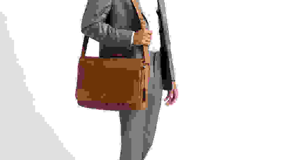 A person in a suit carrying a leather messenger bag.