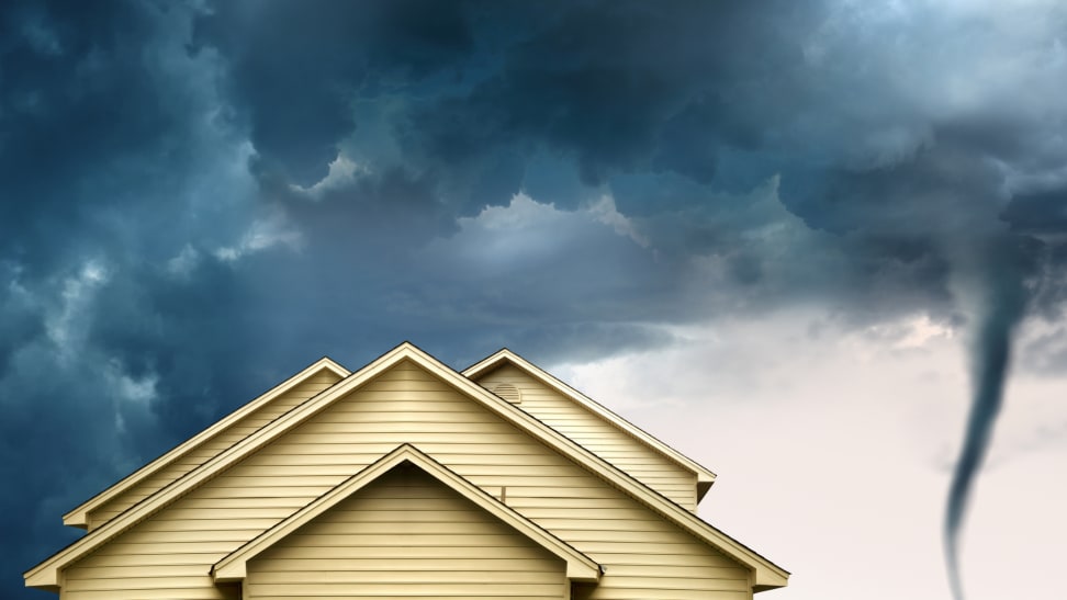 一个棕褐色的家的顶部的特写镜头有一个棕褐色的屋顶的棕褐色屋顶在一个入口的龙卷风和黑暗的天空旁边