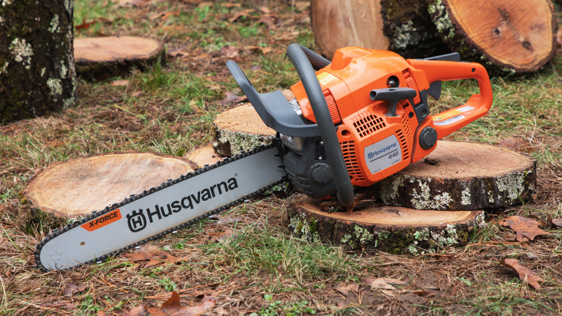 The Husqvarna 440 chainsaw shown outside with a tree stump in the background