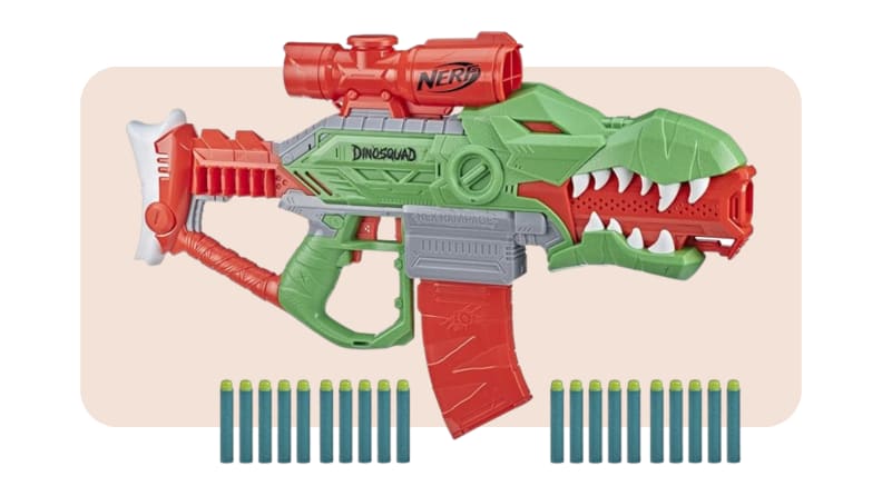 A Nerf DinoSquad blaster with darts lined up along the bottom set against a light peach colored background.