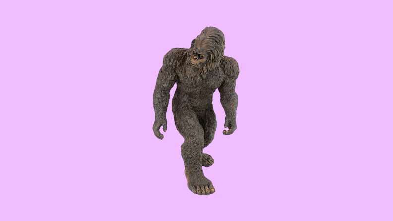 A Bigfoot garden statue in front of a background.