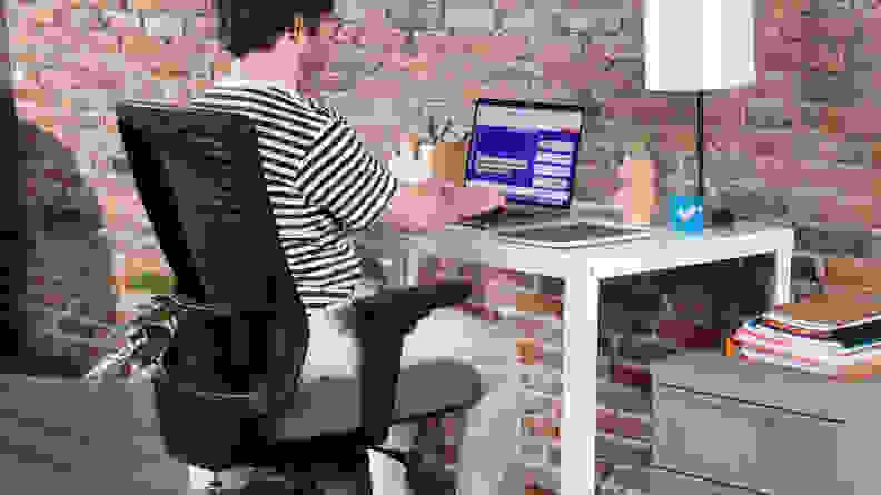 Person sitting in the Tempur-Pedic office chair while working on laptop computer.