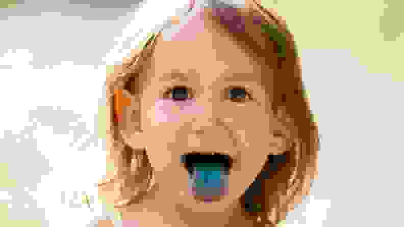 A young child with a bright blue tongue