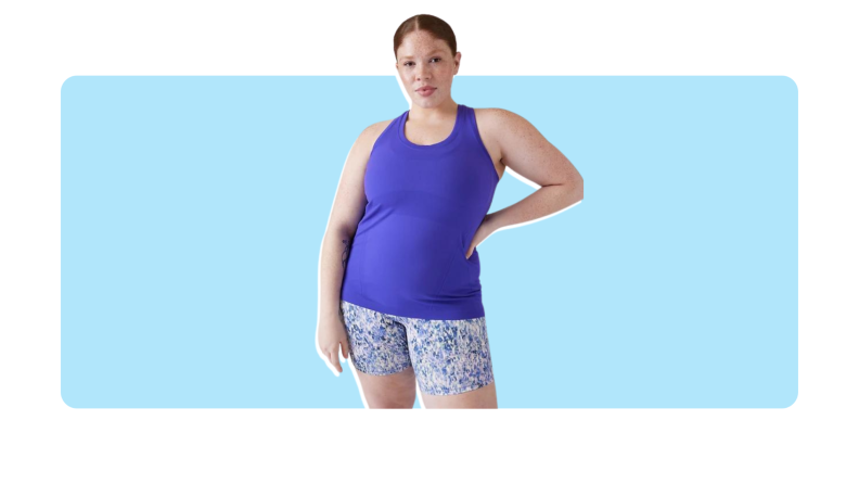 Model poses with hand on hip while wearing the cobalt blue, sleeveless Athleta Momentum Seamless Tank.