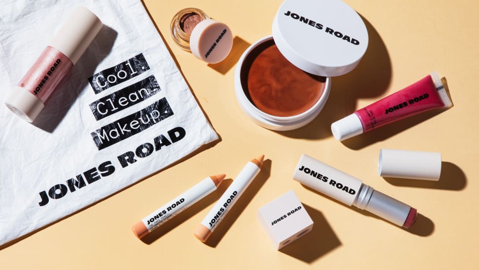 Scattered beauty products including lipstick and cream blush from Jones Road.