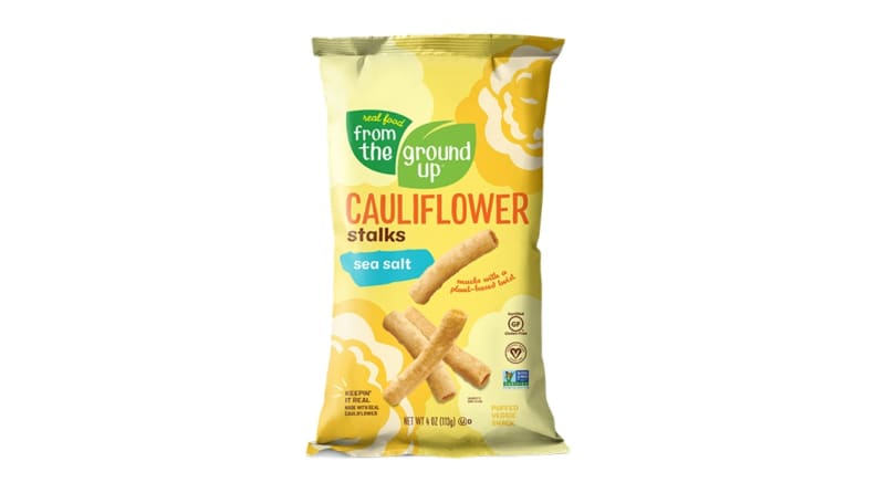 A bag of cauliflower chips with mostly yellow colors and some green accents.