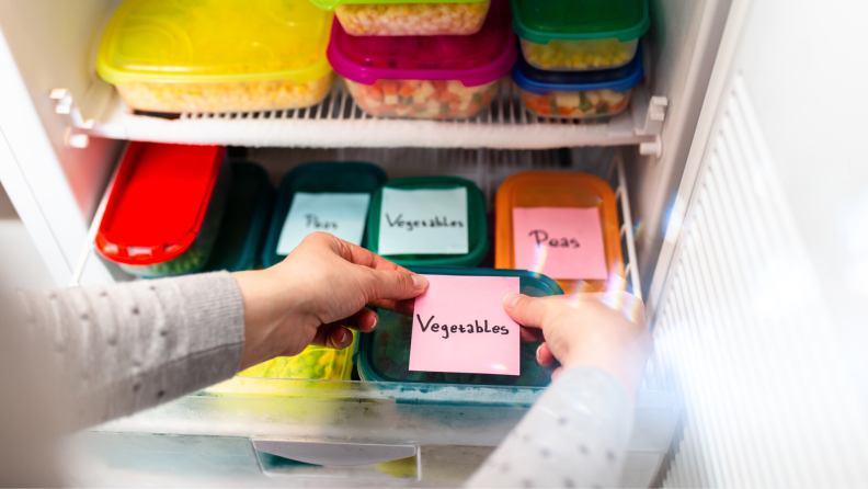 Person labeling freezer container with sticky notes