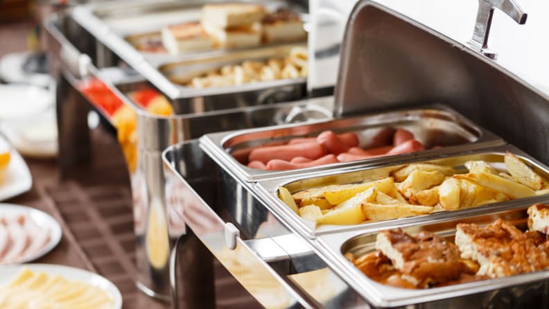 A buffet of chafing dishes filled with food.