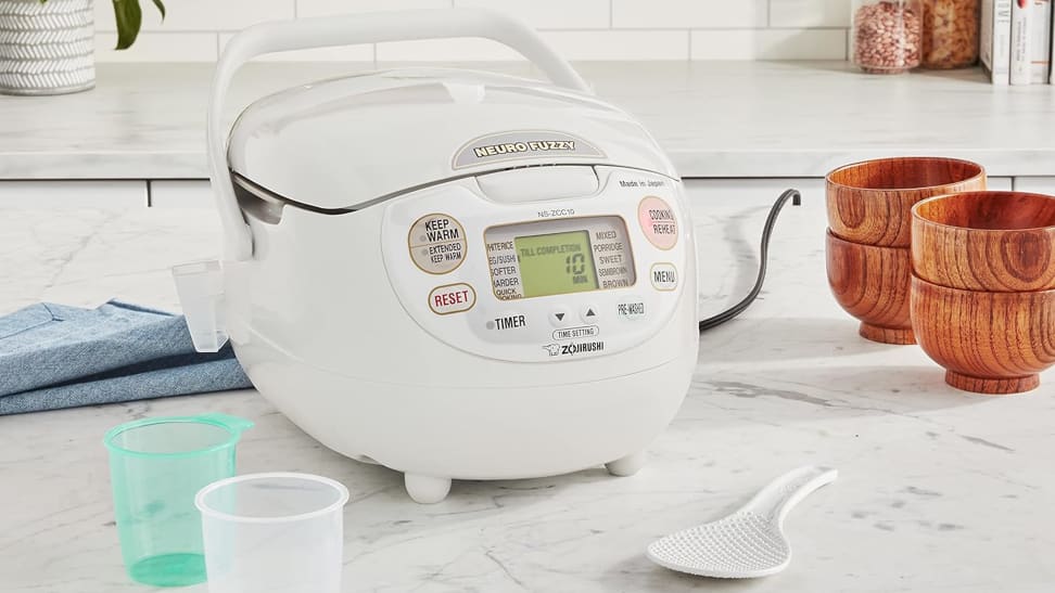 A Zojirushi Neuro Fuzzy rice cooker on a granite surface in a kitchen.