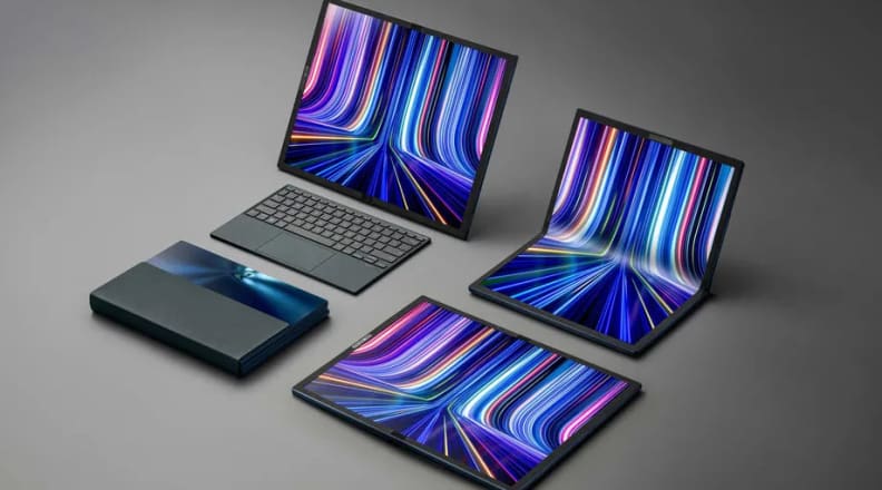 Four Asus Zenbook 17 Fold OLED laptops, laying on a table and folded in different configurations.