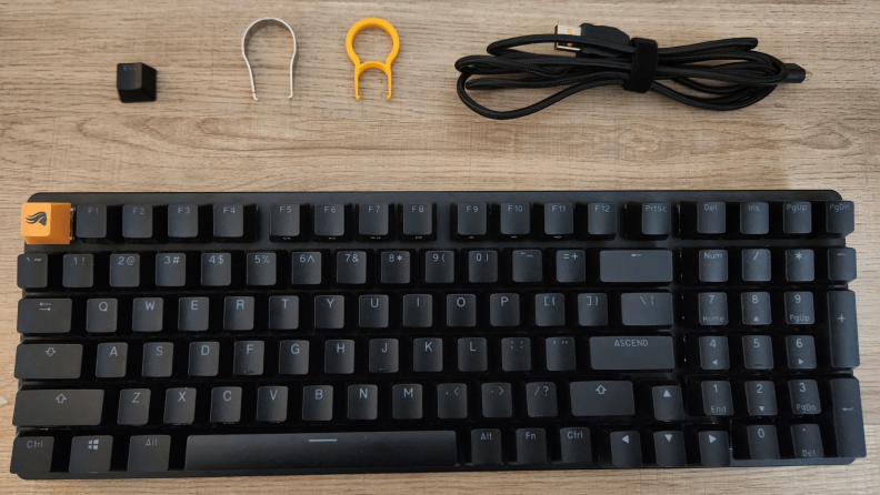 black keyboard with wire and parts laid out above