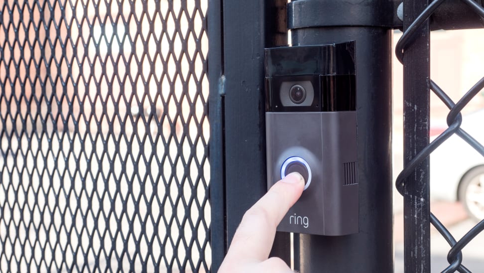 A person pressing a Ring Video Doorbell
