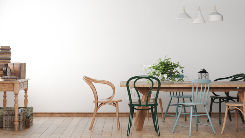 Minimalistic dining room with different styled chairs and wooden dining room table.