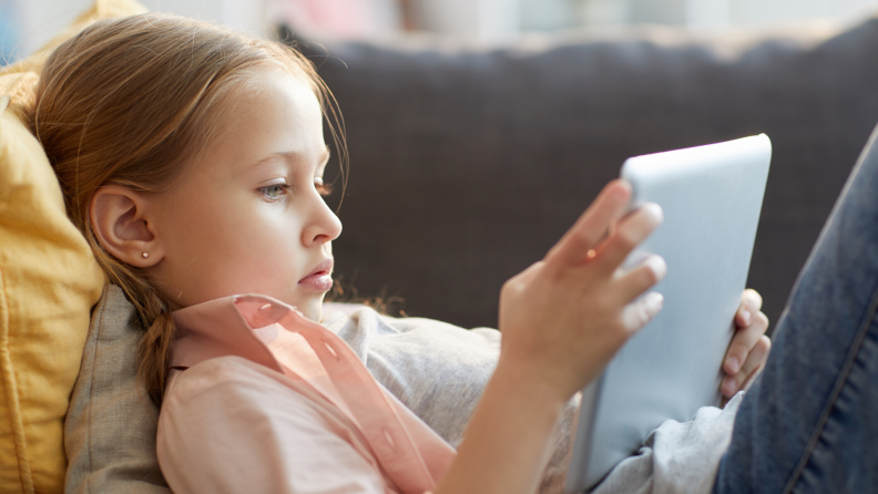 girl using her tablet on the couch