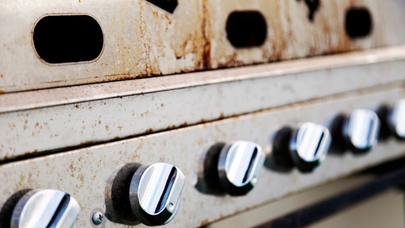 Close-up of grill knobs with rust throughout