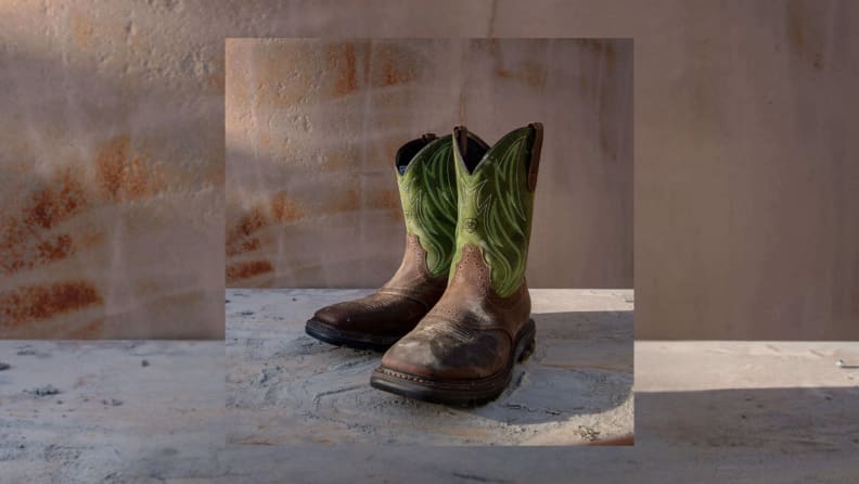 Workboots that look like cowboy boots sitting on a gray table