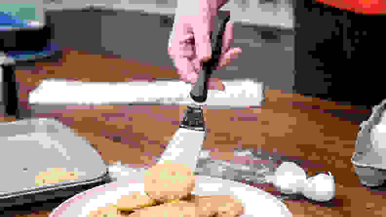 用金属刮刀将饼干移到盘子上的手