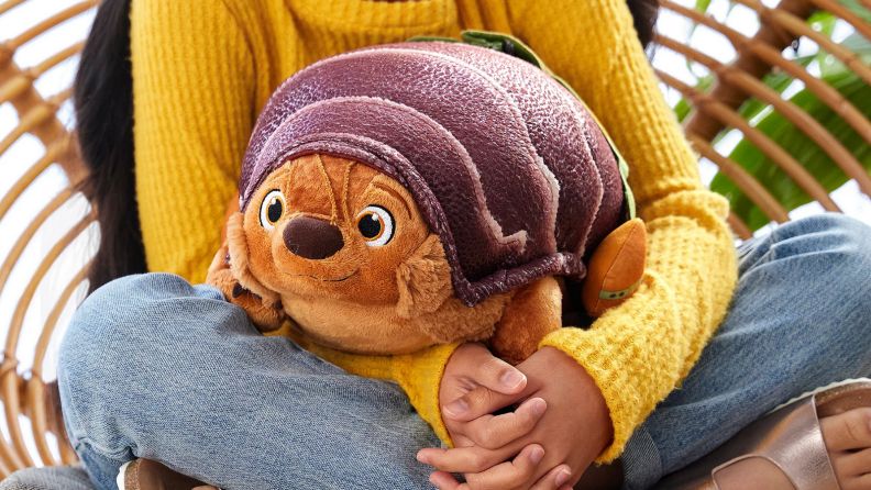 A child holding a TukTuk plushie