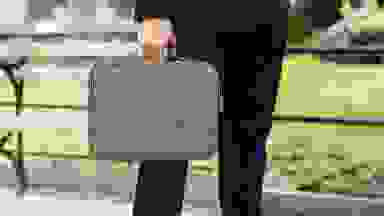 A man carrying his tablet in his tablet case to work.