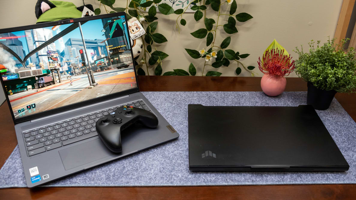 An open Lenovo IdeaPad Gaming Chromebook next to a closed laptop with an Xbox controller resting atop its keypad.