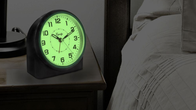 An analog clock with a glowing green face