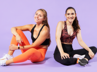 Two women wearing Fabletics leggings and sports bras.