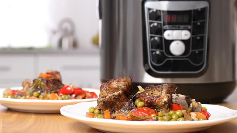Two dishes of What A Crock meat and vegetables in front of a multicooker