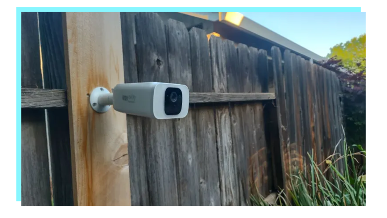 Eufy solar-powered security camera mounted on fence outdoors.