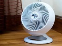 A white Vornado fan sitting on the floor.