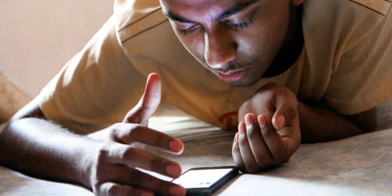 A photo of a man using a smartphone.