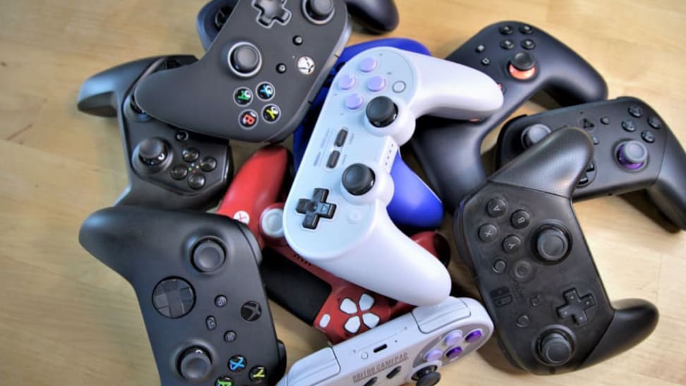 A pile of PC game controllers on a desk