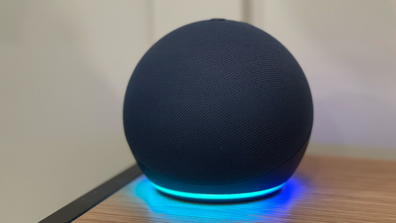 The Echo Dot smart speaker with a blue light illuminating around the bottom