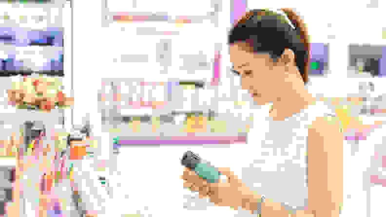 A photo of a woman looking at makeup and skincare products.