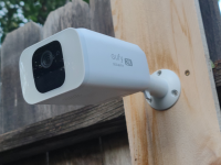 Close up of an outdoor security camera posted to a fence.