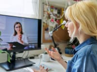 Person using computer for virtual therapy session at home.
