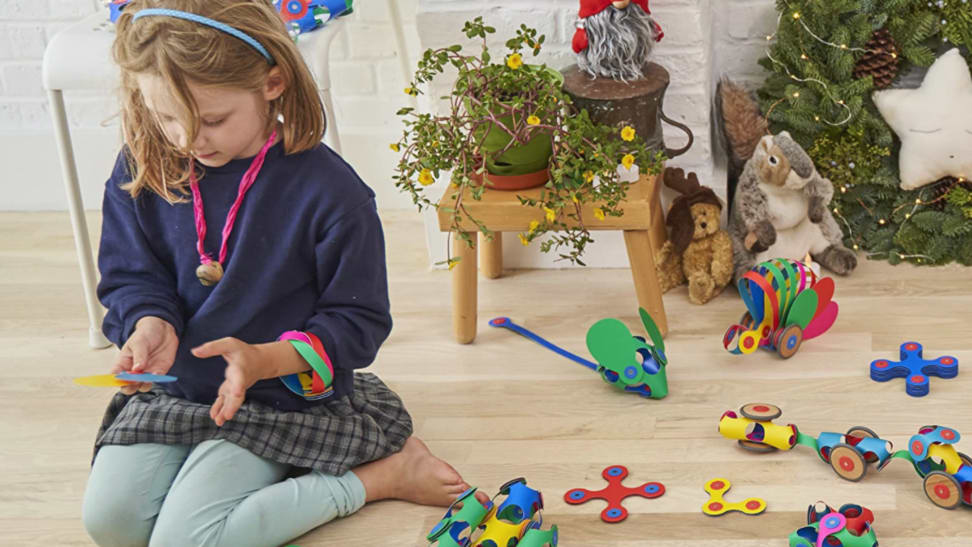 A child plays with Clixo toys with a holiday wreath behind her.